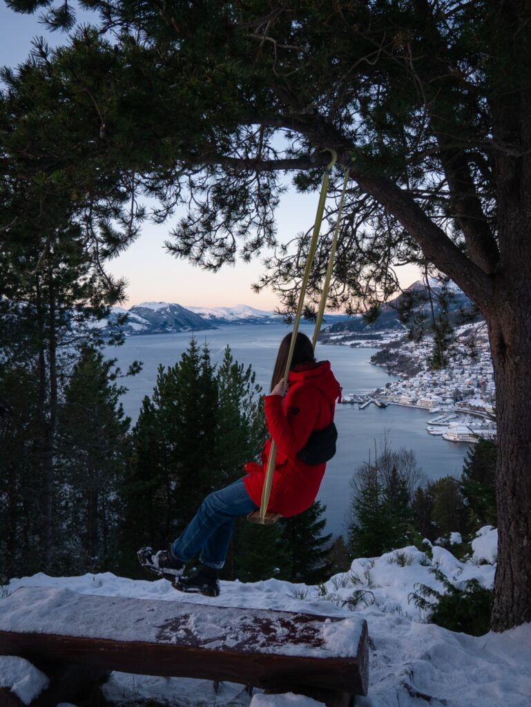 Mia auf einer Schaukel in Norwegen mit einem See und Schnee im Hintergrund | mind me - Der Podcast über die Facetten der Depression